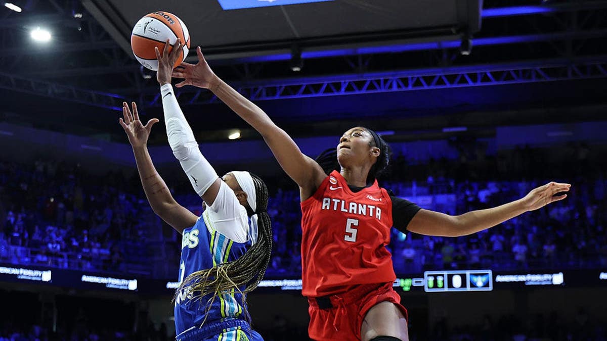 Angel Reese blocks a shot by Odyssey Sims during a basketball game in Arlington, Texas.
