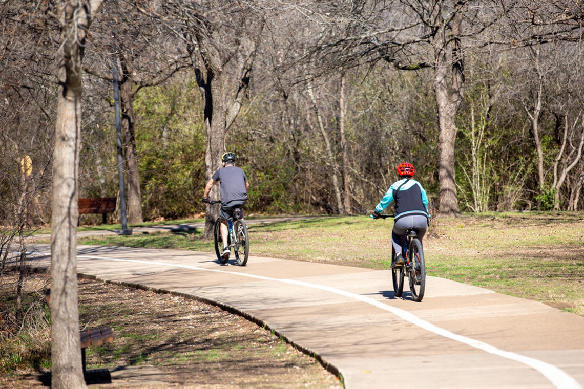 Two people bicycling in a park