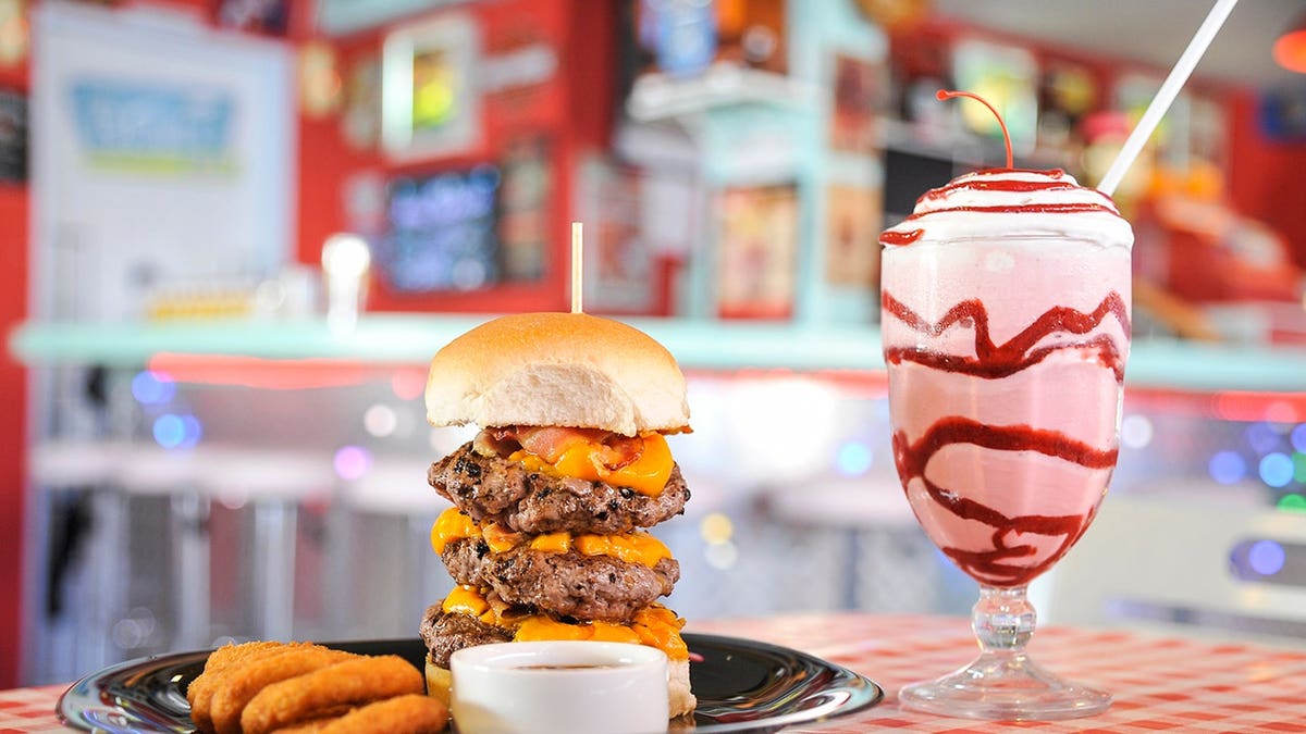 Cheeseburger on a plate with a strawberry milkshake in a glass