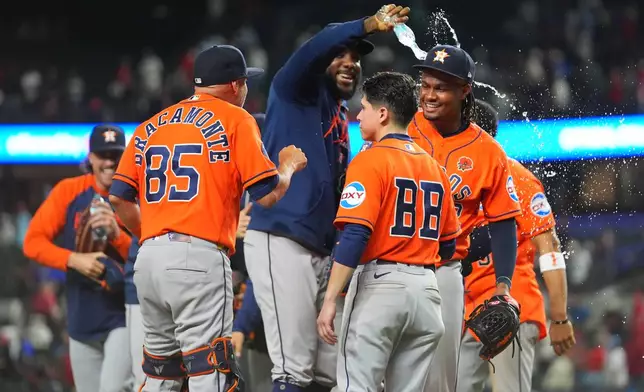 Houston Astros pitcher Alimber Santa, right, is doused with water after pitching in his major league debut and closing a combined no-hitter by his team against the Texas Rangers during a baseball game Monday, May 25, 2026, in Arlington, Texas. (AP Photo/Julio Cortez)