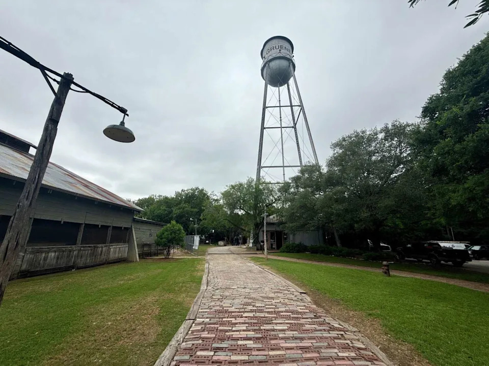 The Gruene water tower stands in the Historic District in Gruene, Texas, on April 30, 2026, still marked by a faint dent from the 1970s demolition attempt. (Courtesy Of Texas Historical Commission)