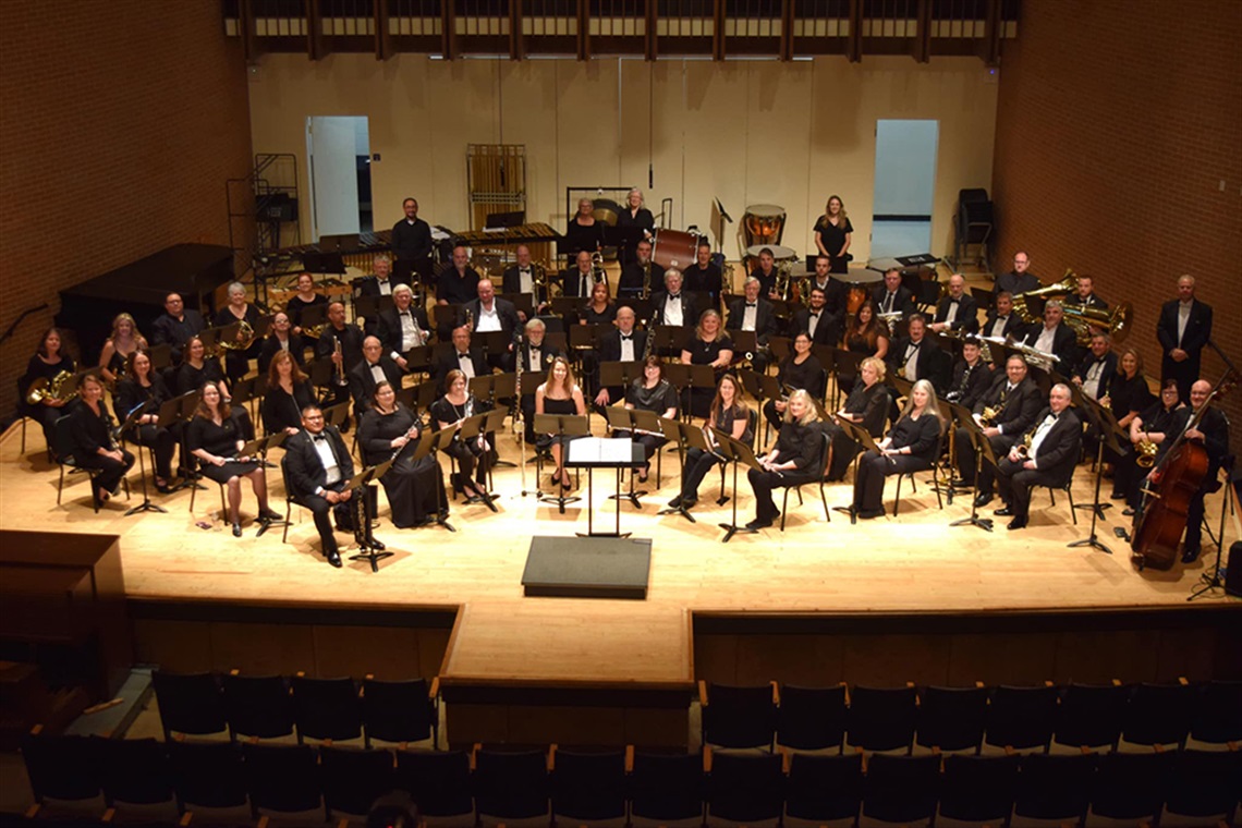 Members of the Arlington Community Band pose for photo with their musical instruments.