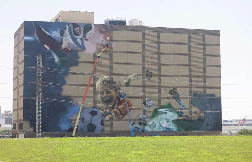 Muralists work on a soccer themed mural ahead of the 2026 FIFA World Cup on the former Jesse R. Dawson State Jail building at 106 W. Commerce Street in Dallas, Thursday, May 14, 2026. The mural will be created by internationally acclaimed artist ROOSART, curated and produced by Street Art for Mankind, and local Dallas artist Daniel Yanez. (Juan Figueroa/The Dallas Morning News)