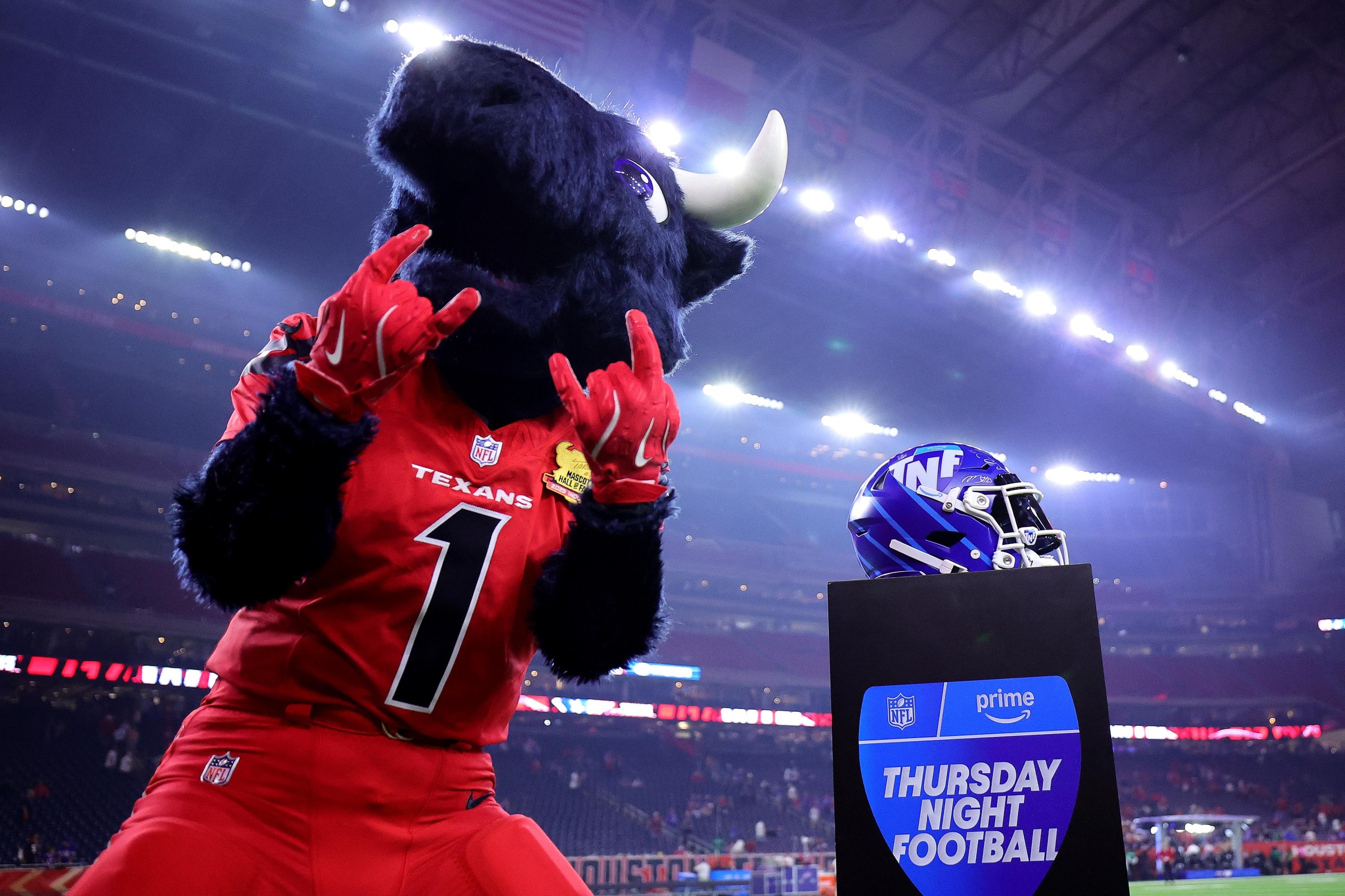 HOUSTON, TEXAS - NOVEMBER 20: Toro, mascot of the Houston Texans, poses next to an Amazon Prime Thursday Night Football helmet after the game against the Buffalo Bills at NRG Stadium on November 20, 2025 in Houston, Texas. (Photo by Alex Slitz/Getty Images)