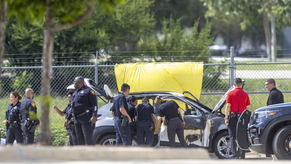 Law enforcement surrounds the scene where two children were found dead inside a car that appeared to have been burned May 15, 2026.