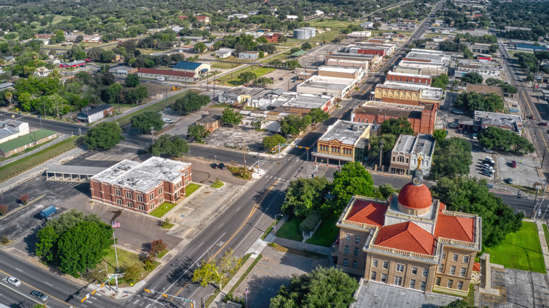 Aerial view of Beeville, Texas, with red roof of courthouse in bottom-right corner.