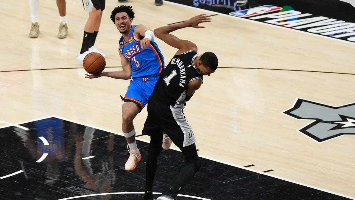 Oklahoma City Thunder guard Jared McCain shooting over San Antonio Spurs forward Victor Wembanyama during a basketball game