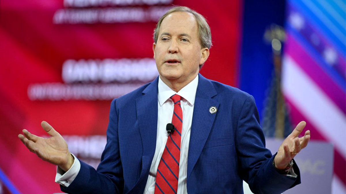 Ken Paxton standing and speaking at a podium
