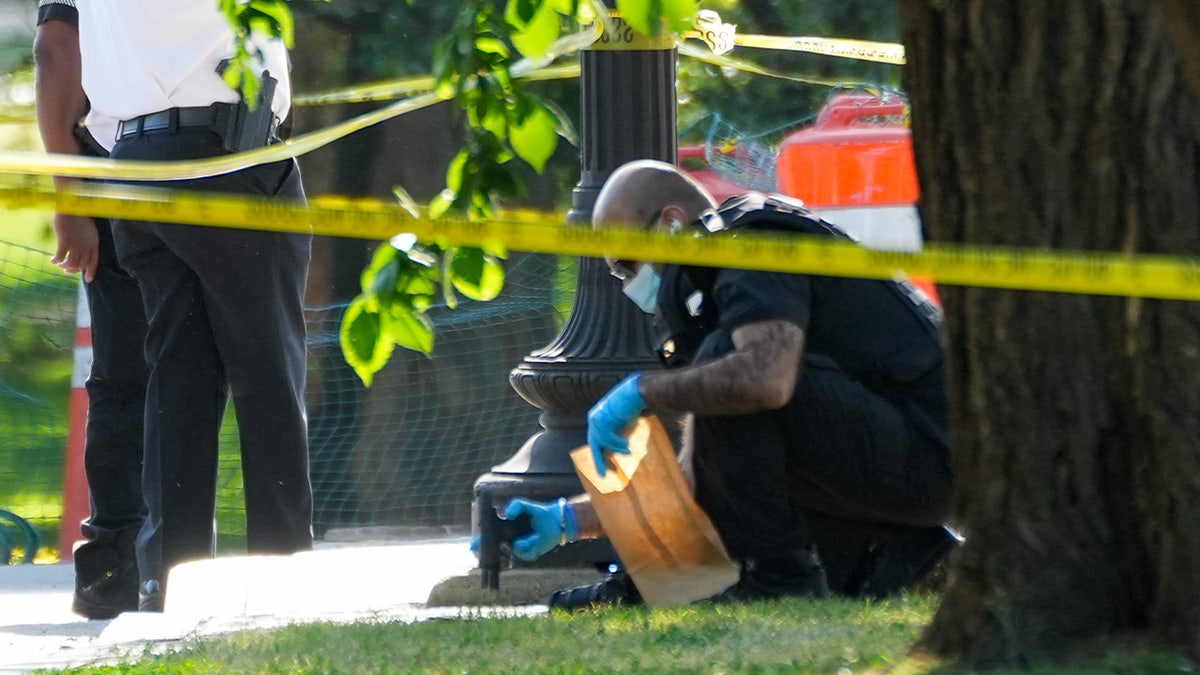 A crime scene technician removes a gun on the National Mall in Washington, D.C.