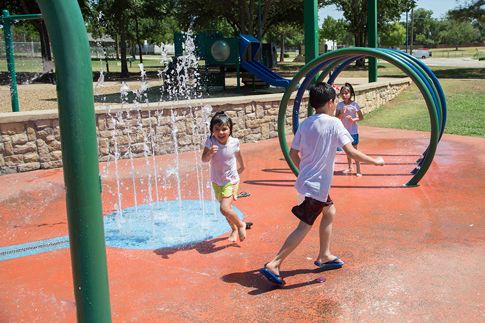 Children playing in water at California Lane Park splash pad