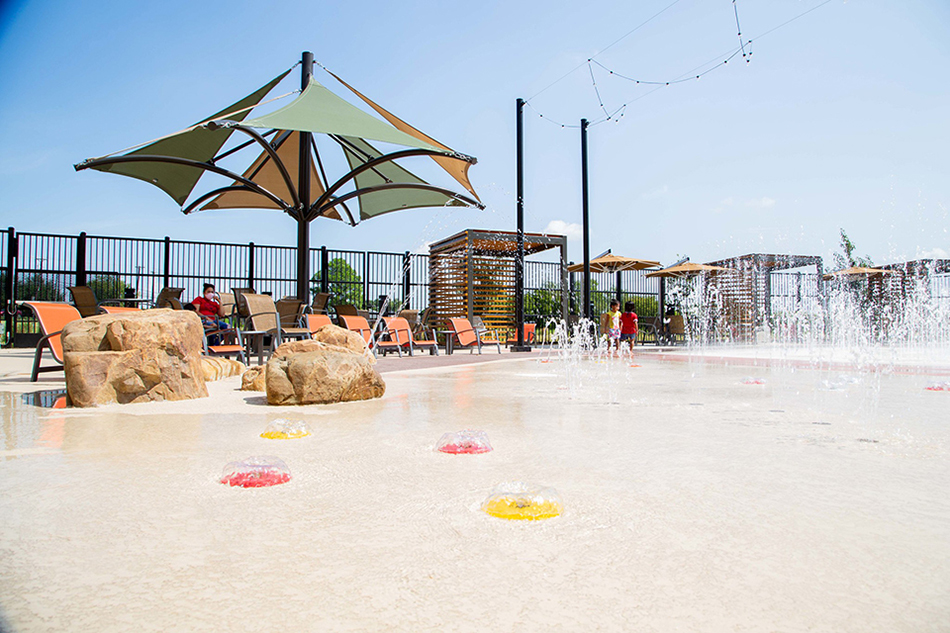 Gated splash pad with shade umbrella at The Beacon Recreation Center