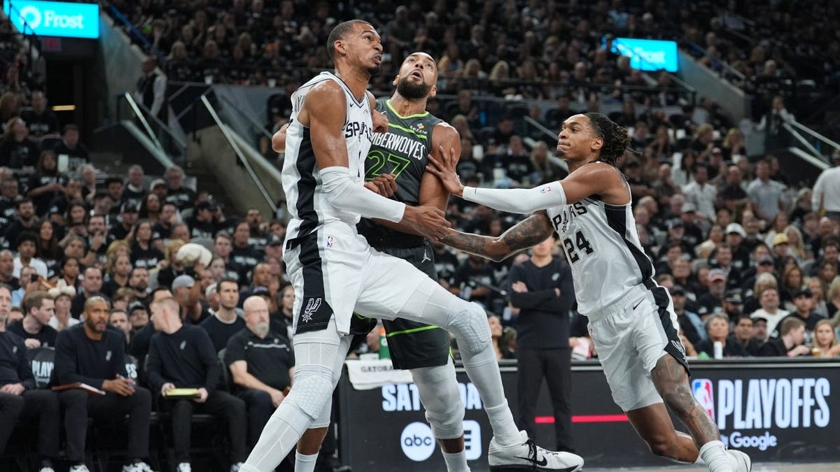 San Antonio Spurs big Victor Wembanyama and SG Devin Vassell fight Minnesota Timberwolves C Rudy Gobert for a rebound during a free-throw attempt at Frost Bank Center.