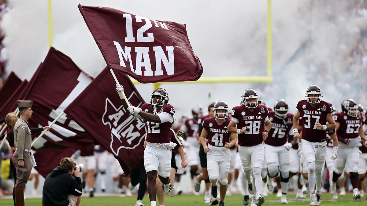 Texas A&M Aggies football players running onto the field at Kyle Field