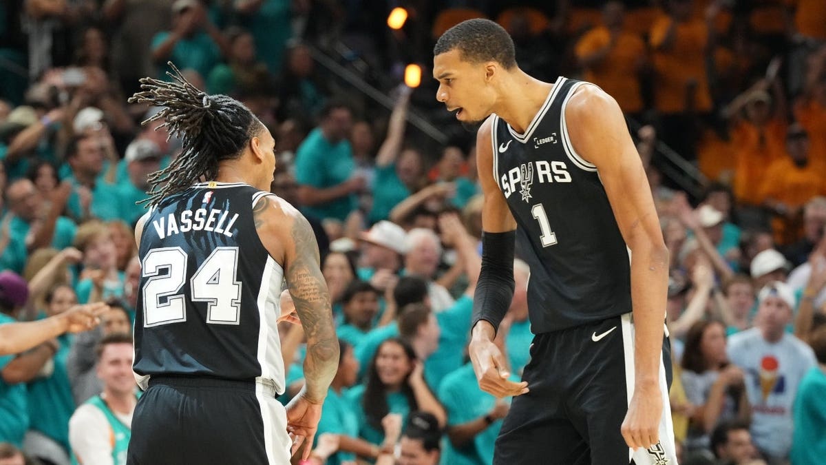 San Antonio Spurs forward Victor Wembanyama and guard Devin Vassell reacting during a basketball game