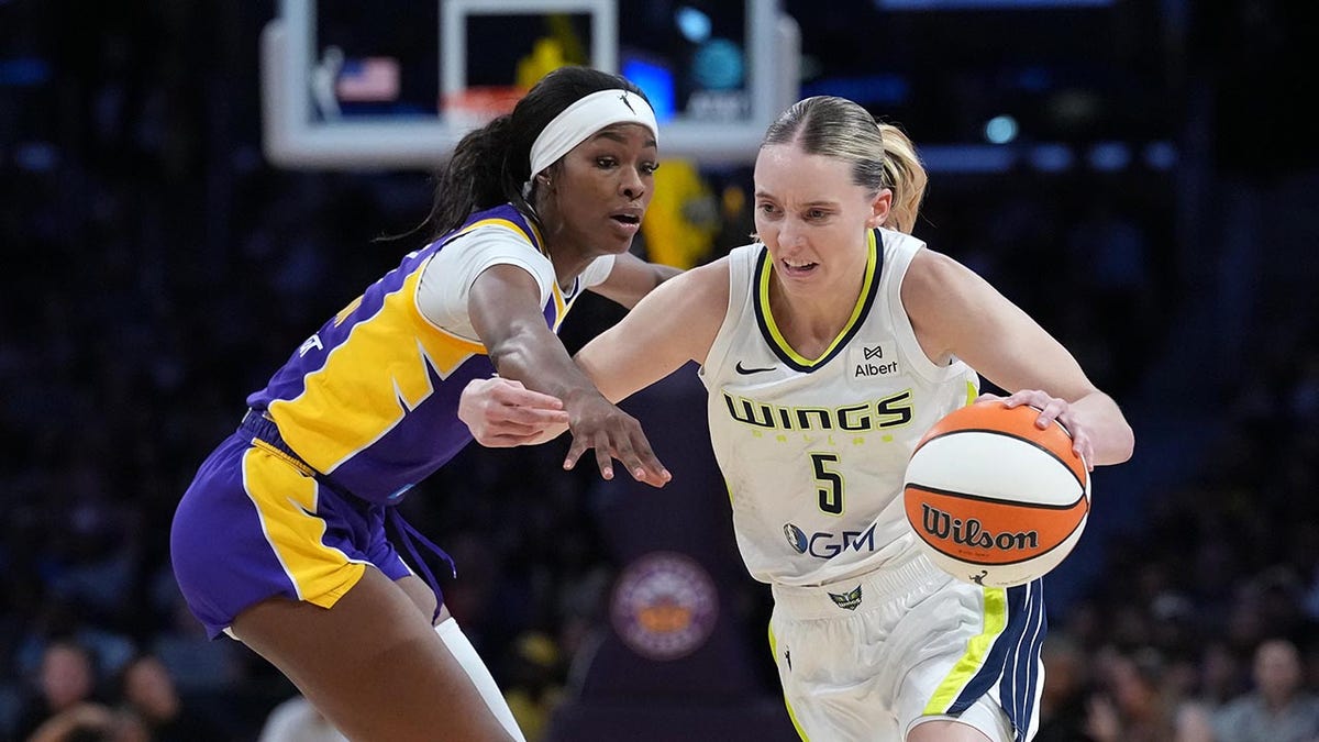 Dallas Wings guard Paige Bueckers dribbling against LA Sparks forward Rickea Jackson at Crypto.com Arena