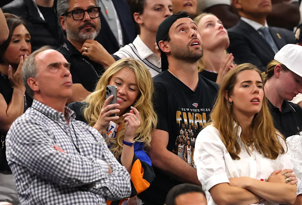 Sydney Sweeney and Scooter Braun look on during the fourth quarter in Game Five of the 2026 NBA Finals between the San Antonio Spurs and the New York Knicks at Frost Bank Center on June 13, 2026 in San Antonio, Texas.
