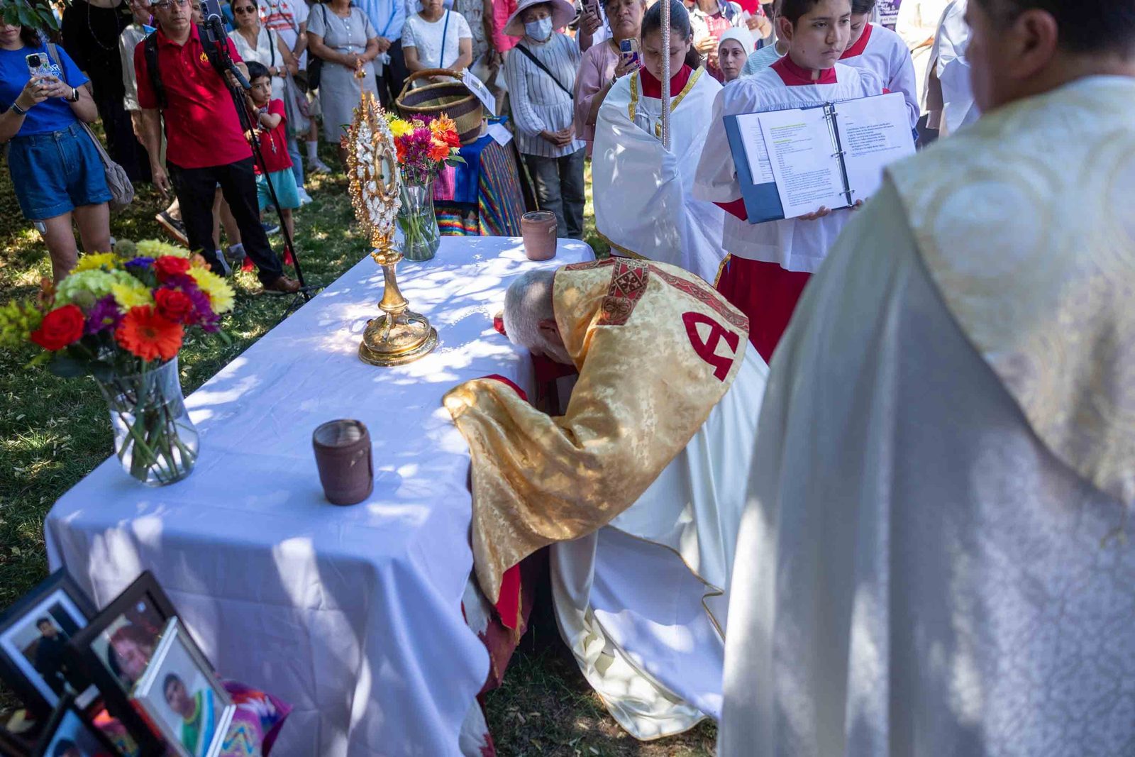 Bishop-elect Emilio Biosca Agüero prays before the Blessed Sacrament at an altar prepared by St. Camillus Parish in Silver Spring during a June 7 Corpus Christi procession held in solidarity with immigrants in Washington. Members of the parish’s Immigrant Support and Advocacy Network carried a banner honoring parishioners detained over their immigration status and collected prayer intentions from families. (Catholic Standard photo by Mihoko Owada)