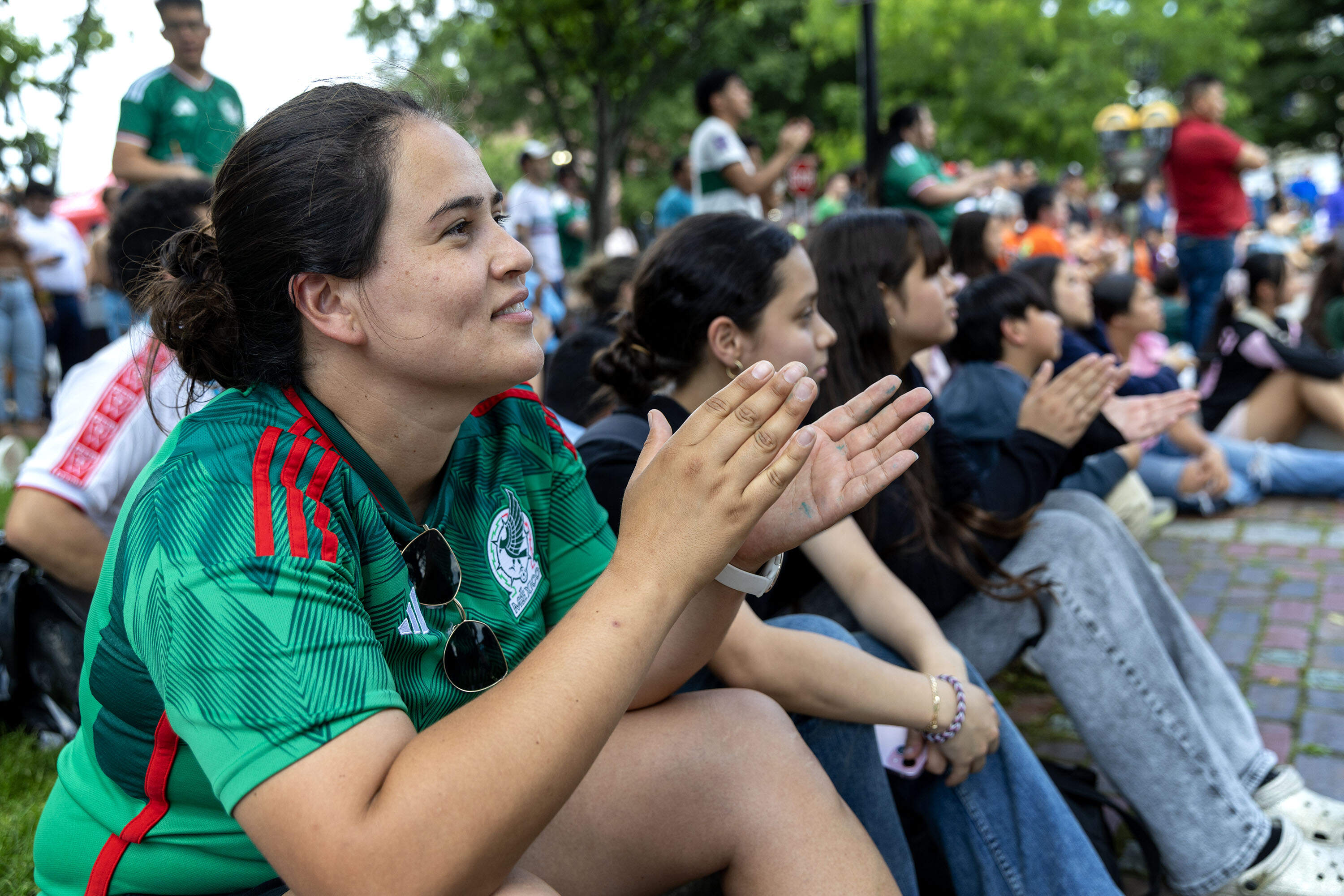 Karla Gutierrez, senior program director of Soccer Without Borders Massachusetts watches the first soccer match of the 2026 World Cup in Chelsea Square. (Robin Lubbock/WBUR)