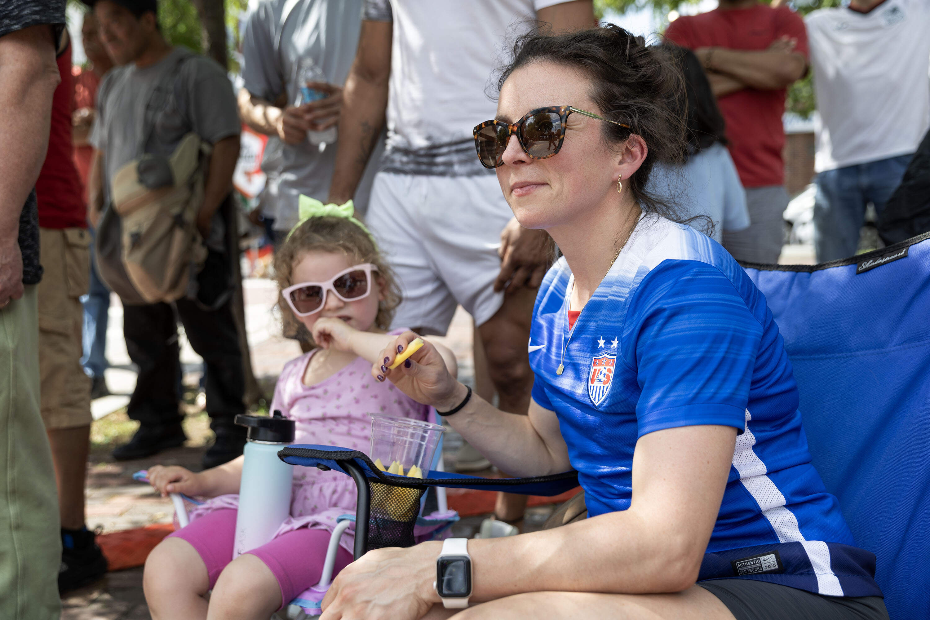 USA field hockey player Hillary Paul Metcalf sits in the shade at a World Cup watch party in Chelsea Square. (Robin Lubbock/WBUR)