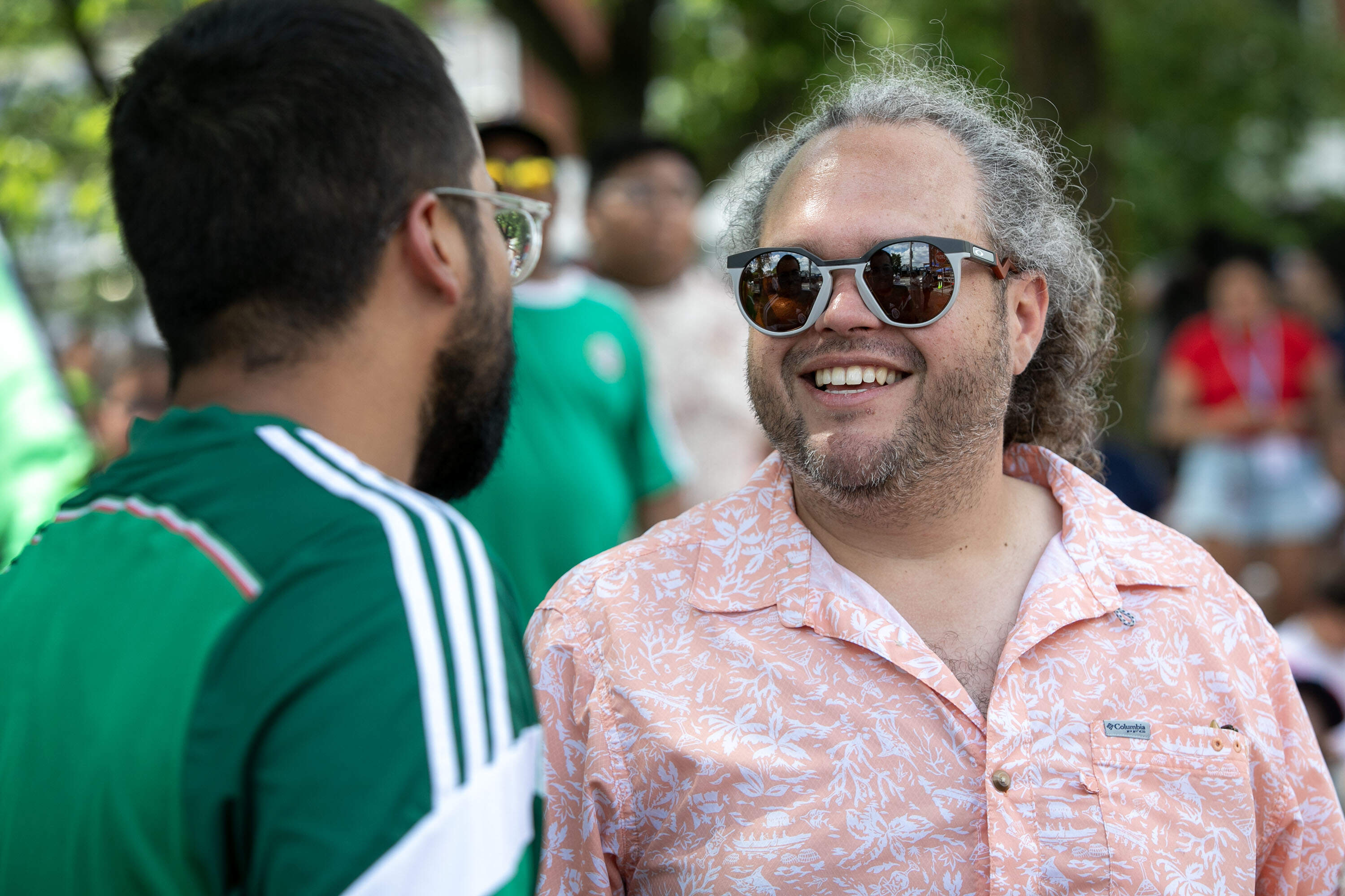 Omar Miranda, a civic design specialist for Chelsea, talks with a fan at the "Fiesta Fútbol." (Robin Lubbock/WBUR)