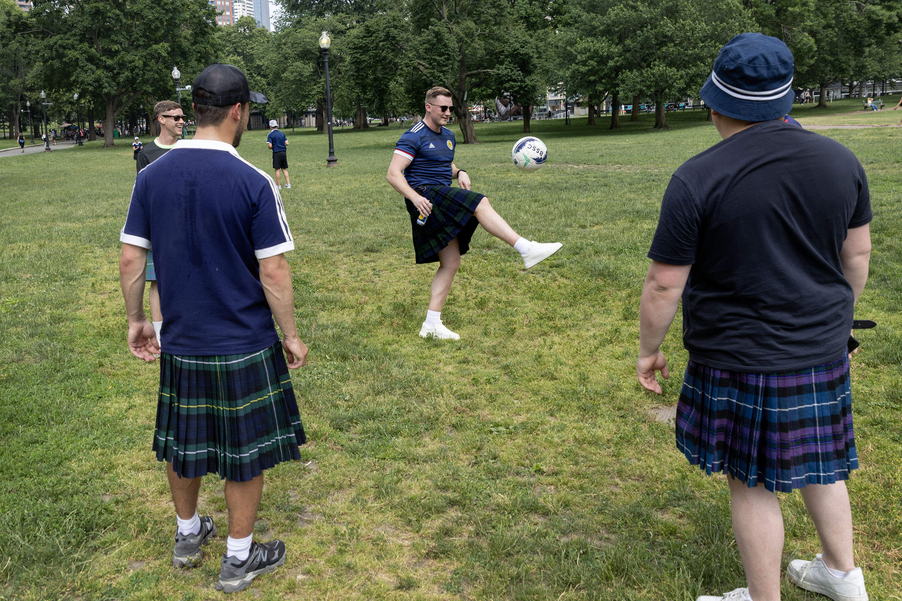 A group of Scotland fans from Oban pass a soccer ball in a circle on Boston Common. (Robin Lubbock/WBUR)