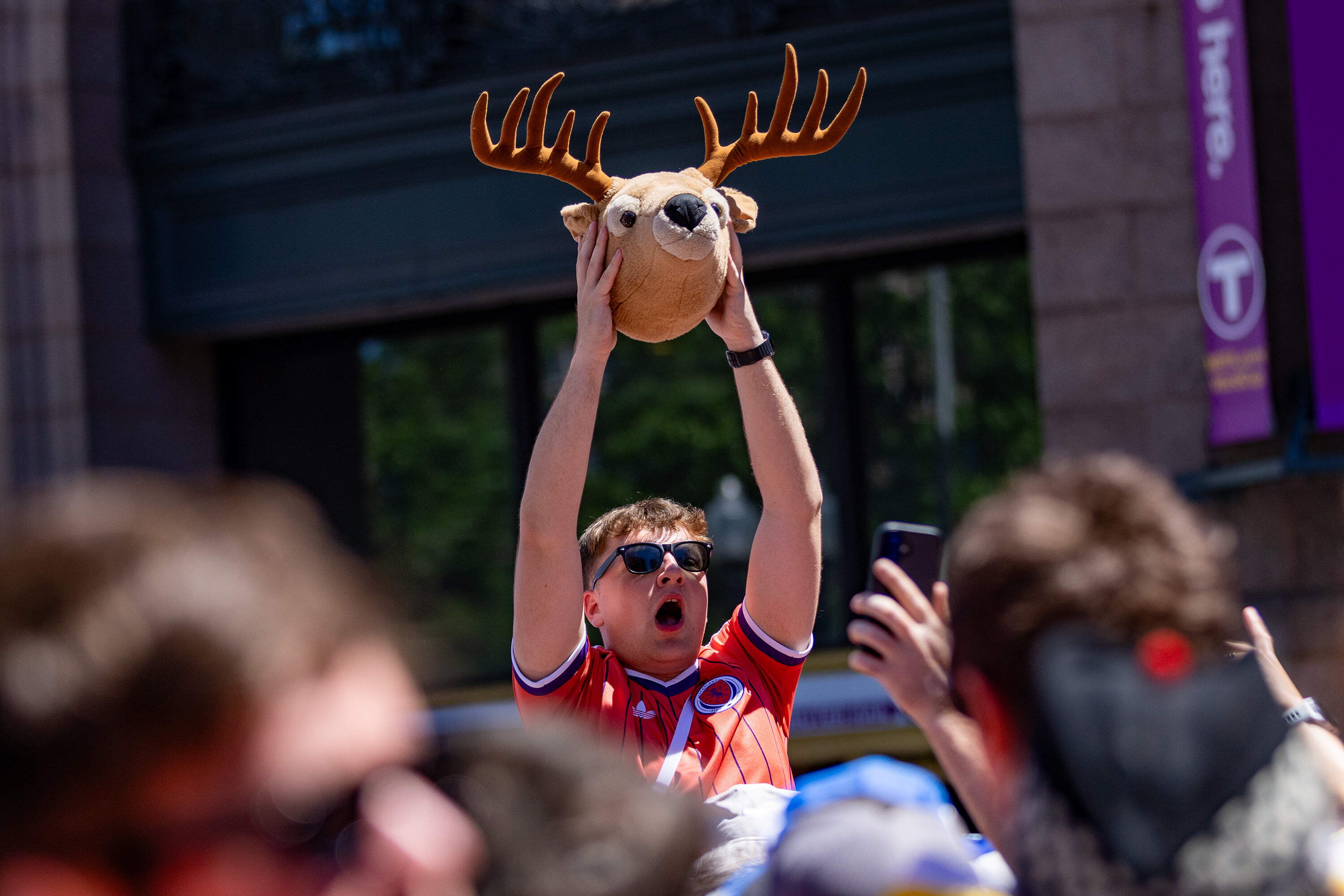 A Scottish fan chants while holding a plush deer head while waiting to board an MBTA train at South Station. (Jesse Costa/WBUR)