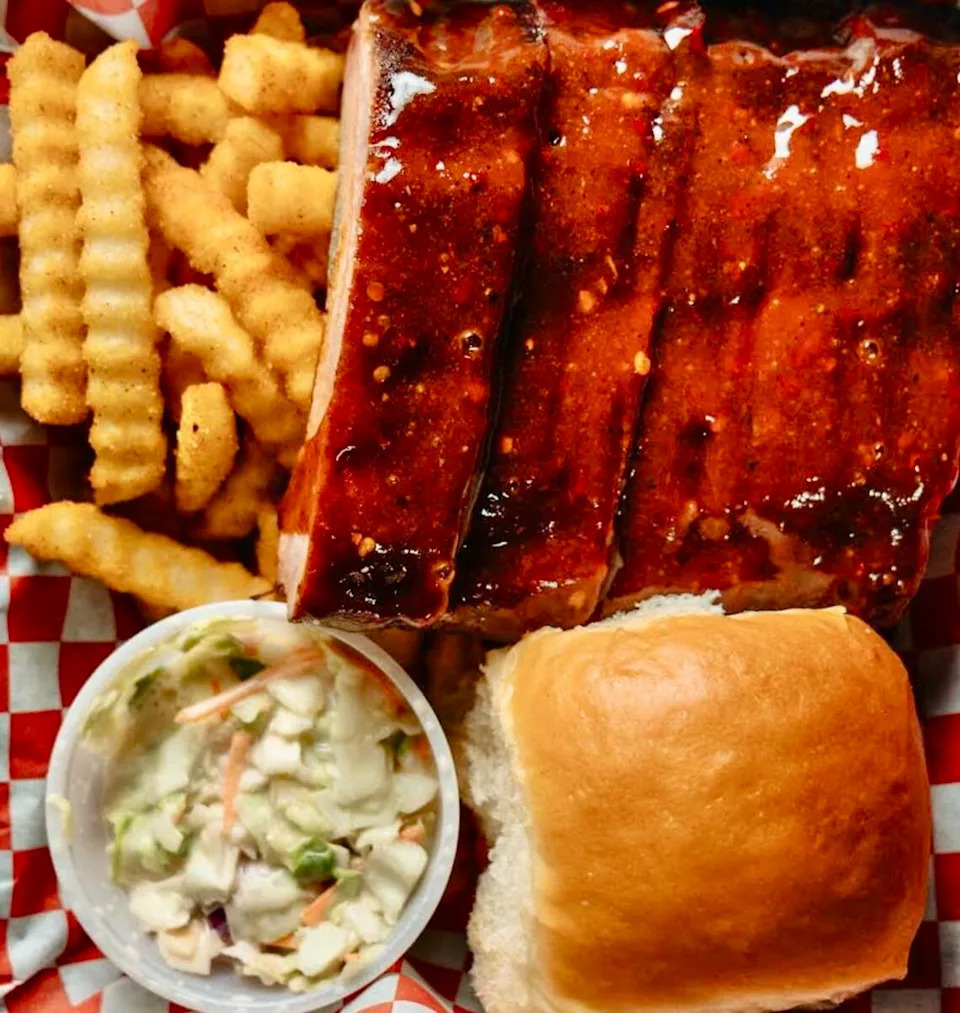 A baby back rib dinner with hot honey sauce, fries and slaw at Ribbee’s in Fort Worth.