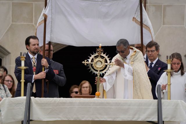 Father John Raphael places the Blessed Sacrament on an outdoor altar for veneration during a eucharistic procession at Christ the King in honor of the Feast of Corpus Christi on Sunday, June 7. Photo by Chris Musacchio