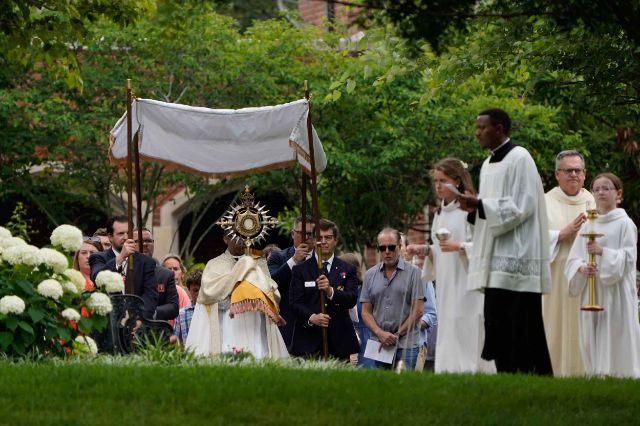 Father John Raphael, pastor of Christ the King Church, leads a eucharistic procession after the 11 a.m. Mass on Sunday, June 7, at the church. Photo by Chris Musacchio