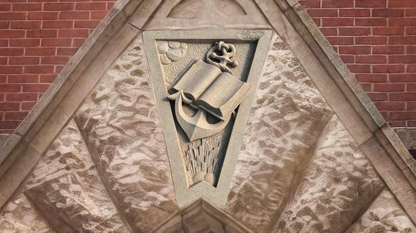 A salvaged stone from the original First Dallas Baptist sanctuary featuring a carved Bible and anchor. 