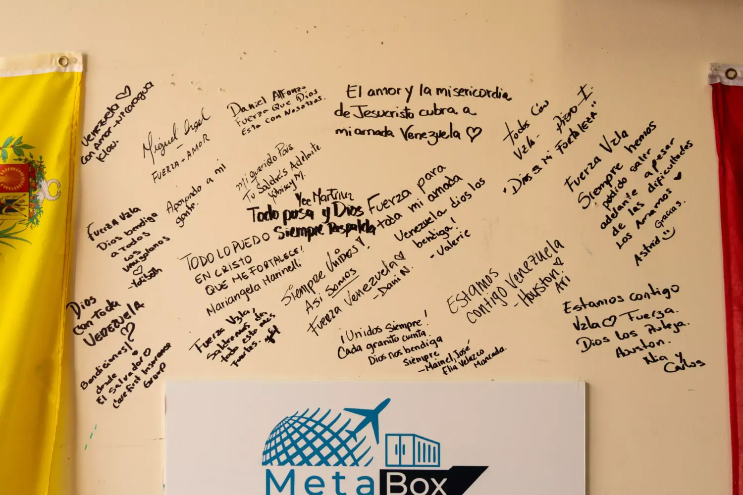 Messages of hope and support cover a wall beside a Venezuelan flag at MetaBox Cargo in Katy, Texas, on Thursday.