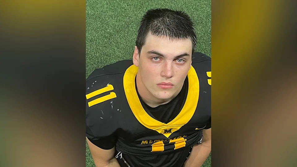 Austin Metcalf standing and smiling outdoors