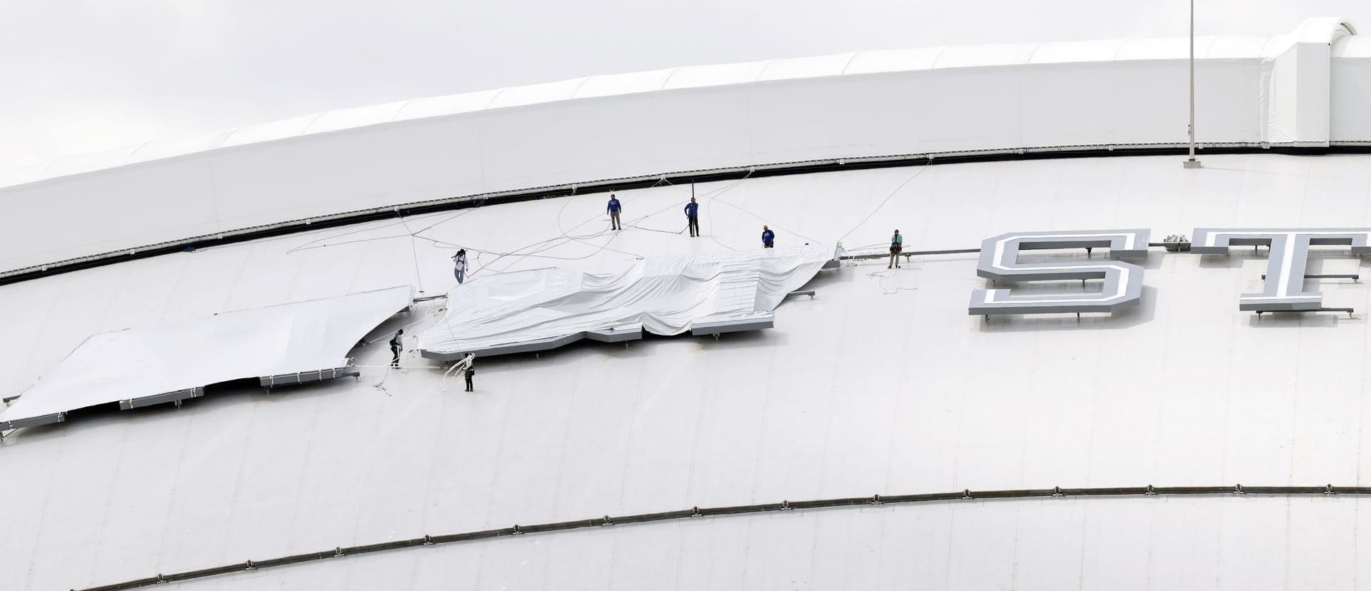 Ahead of the FIFA World Cup matches, crews drape the AT&T Stadium sign atop the stadium’s roof in Arlington, Texas, June 4, 2026. The stadium will be referred to as Dallas Stadium.