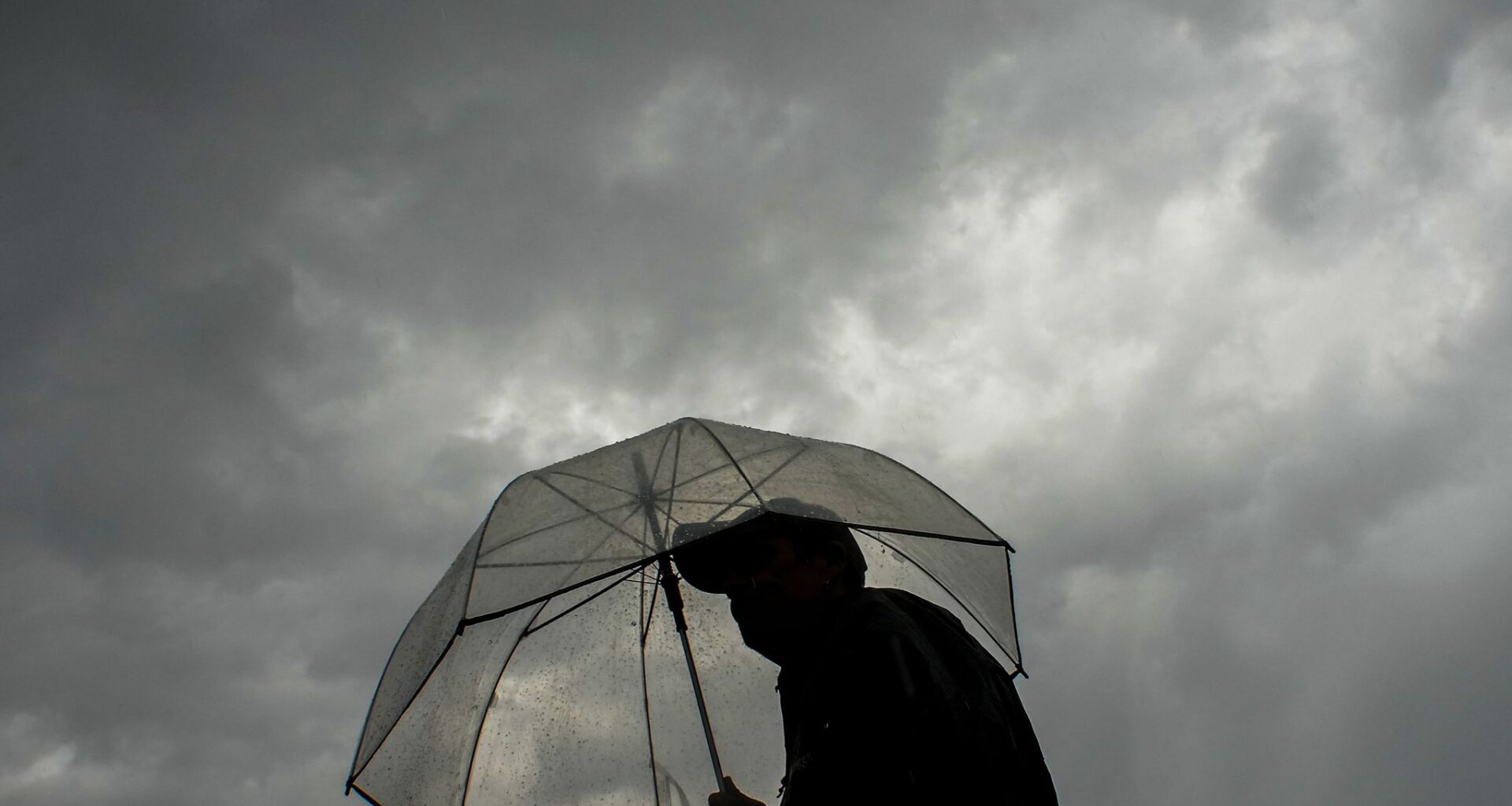 Fans head for the stadium in a heavy rain before a baseball game between the Texas Rangers and the Houston Astros at Globe Life Field  on Monday, May 25, 2026, in Arlington.