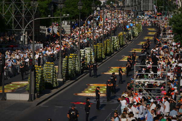 People wait for the arrival of Pope Leo XIV ahead of a Holy Mass and Corpus Christi procession at Plaza de Cibeles in Madrid, Spain, Sunday, June 7, 2026, on the second day of his seven-day apostolic visit to mainland Spain and the Canary Islands. (AP Photo/Manu Fernandez)