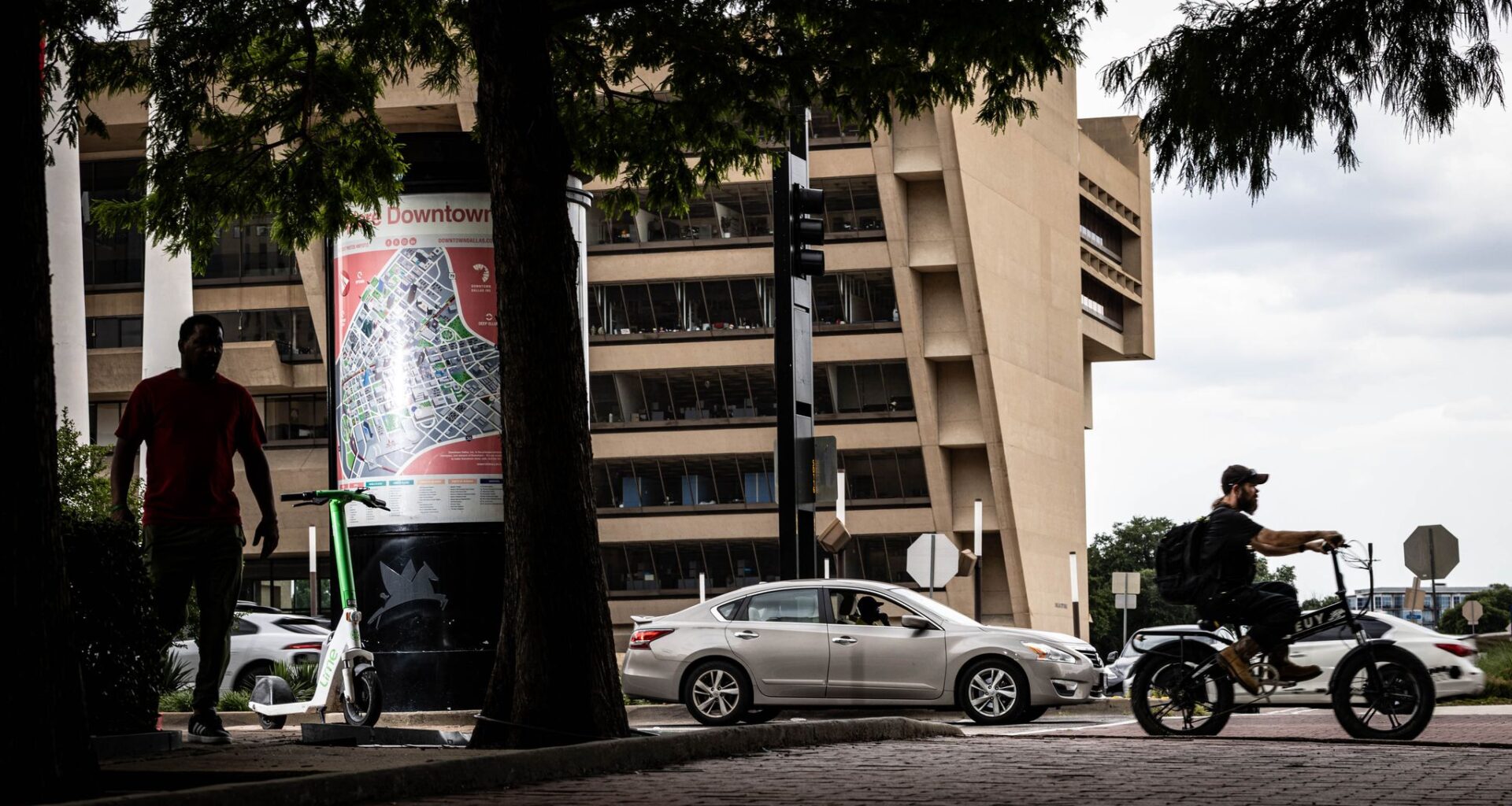 Traffic travels along Young Street in front of Dallas City Hall in May 2026.