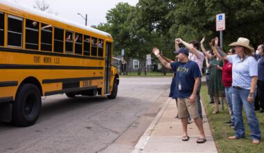 School staff wave to a bus as students leave following the last day of school at International Newcomer Academy, a specialized campus for immigrant and refugee students in Fort Worth, on Thursday, May 21, 2026. 