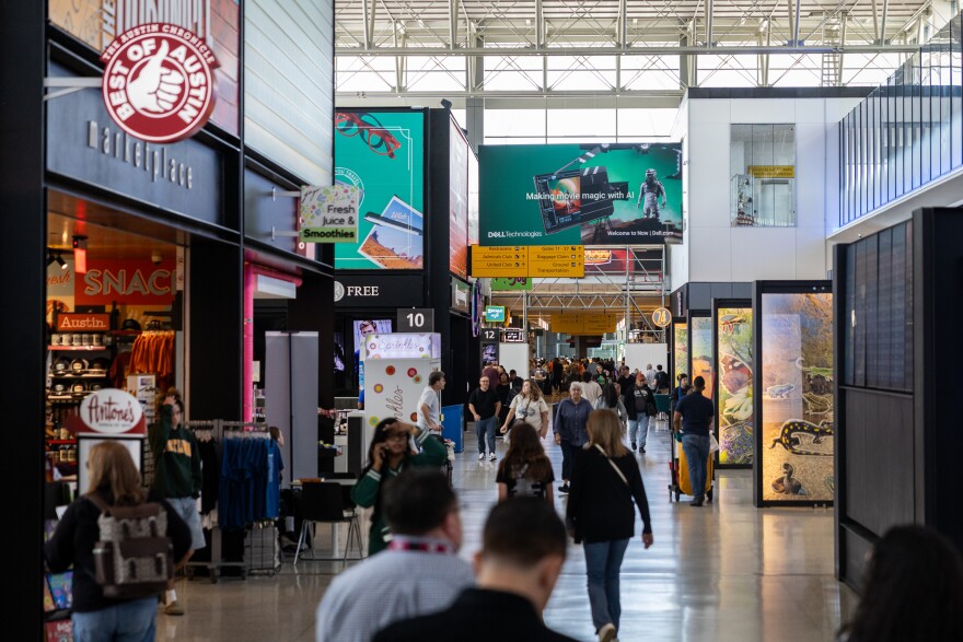 Flyers and employees walk past shops, restaurants, and airplane gates at Austin-Bergstrom International Airport on Monday, April 21, 2025.
