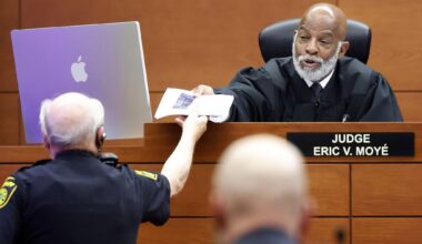 The bailiff hands paperwork to State of Texas Presiding Judge Eric Moyé who later ruled on behalf of three Dallas City Council members who sued the city to delay a vote on the future of City Hall. The judge granted a temporary restraining order to halt a vote by City Council tomorrow. The hearing took place at the George L. Allen, Sr. Courts Building June 9, 2026.