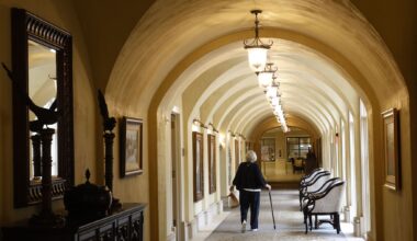 A woman walks in a hallway at Edgemere, senior living community, Friday, May 1, 2026, in Dallas.