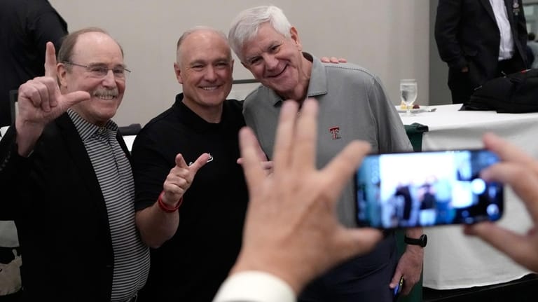 Texas Tech football coach Joey McGuire, center, poses for photographs...