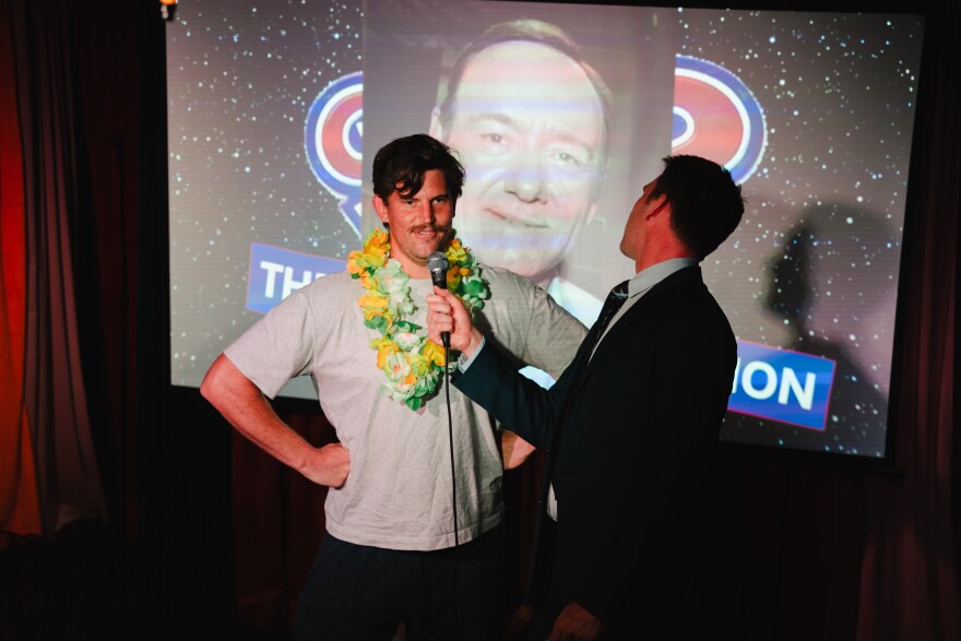 Trenton Bradley with audience member on stage at Did I Win? at Fallout Theater on Saturday, May 9, 2026. Isak Kotecki/KUT