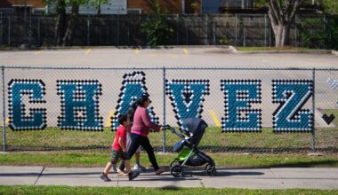 Pedestrians walk past the parking lot of the Cesar Chavez Learning Center in Dallas, Thursday, March 19, 2026. (AP Photo/Julio Cortez)