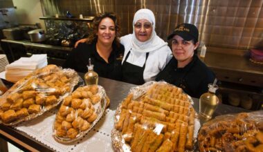 Nadia Elmaroudi (from left), Haja Latifa Elmaroudi and Wafa Elmaroudi behind a counter filled with desserts at Moroccan Bites Tagine.
