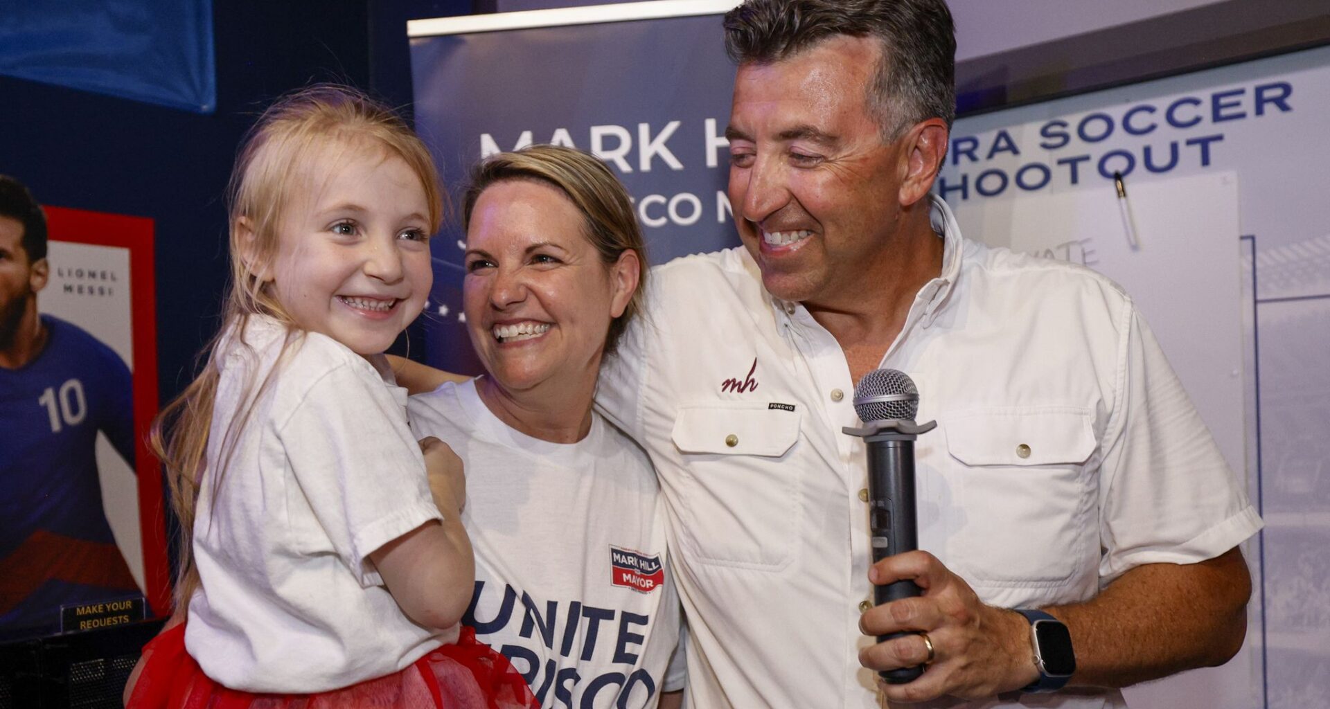 Frisco mayoral candidate Mark Hill smiles with his wife Tiffany and daughter Emily, 7, as he prepares to speak to supporters during his election night watch party at The Frisco Bar & Grill on Saturday, June 13, 2026, in Frisco.