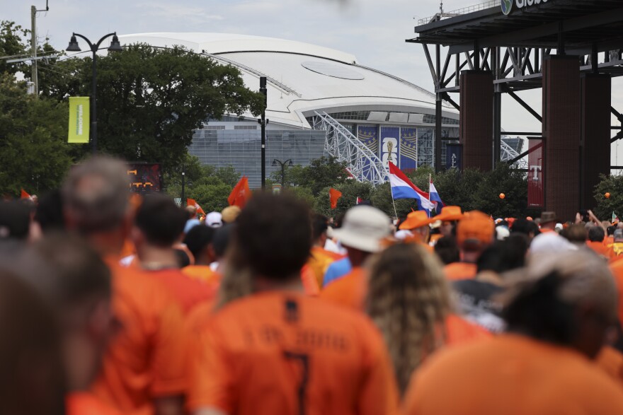 AT&T Stadium, known as Dallas Stadium for the World Cup, is seen past Dutch fans marching before the Netherlands and Japan World Cup game Sunday, June 14, 2026, in Arlington.