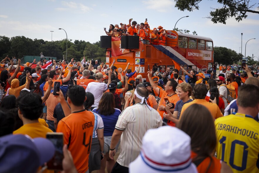 Dutch fans march with a double decker bus before the Netherlands and Japan World Cup game Sunday, June 14, 2026, in Arlington.