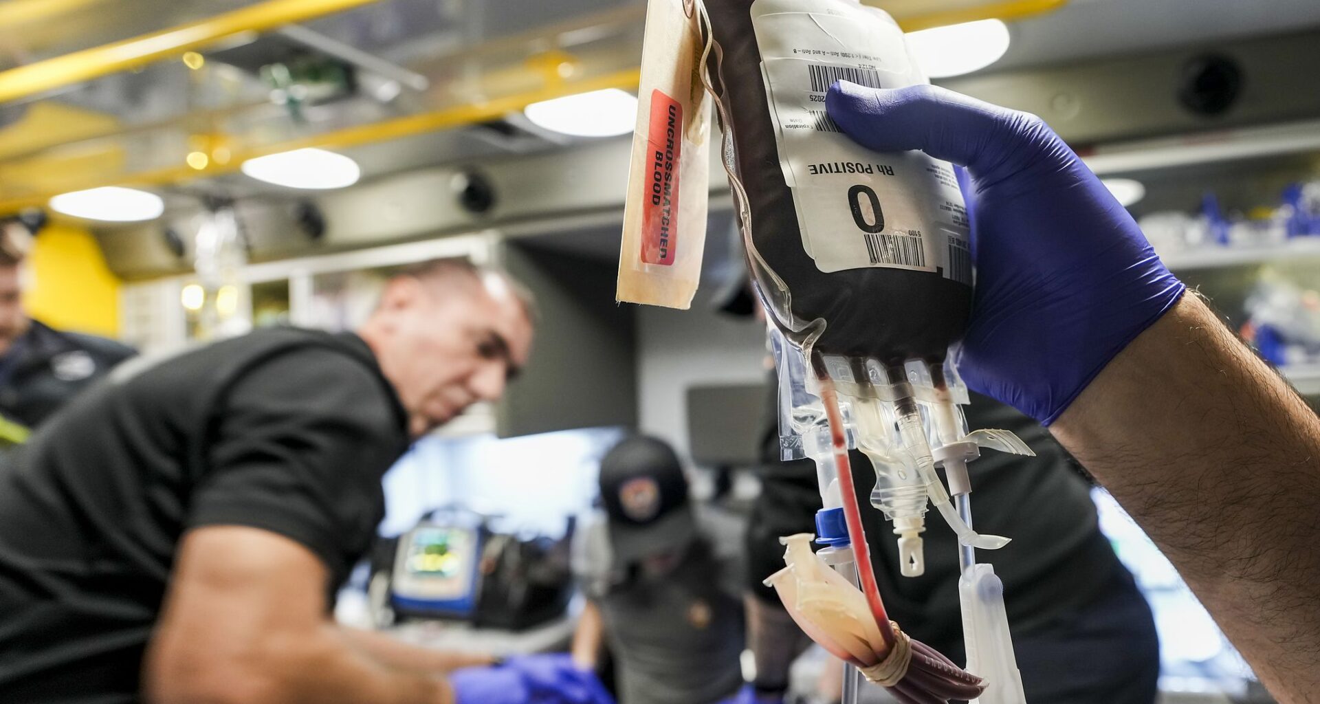 Fort Worth Fire Department Capt. Trent Robinson works to transfuse a gunshot victim with a unit of blood in the back of an ambulance in Fort Worth on a late fall evening in 2025. The department has initiated a mobile blood program, which has delivered blood to hemorrhaging patients in the field since April.