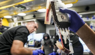 Fort Worth Fire Department Capt. Trent Robinson works to transfuse a gunshot victim with a unit of blood in the back of an ambulance in Fort Worth on a late fall evening in 2025. The department has initiated a mobile blood program, which has delivered blood to hemorrhaging patients in the field since April.