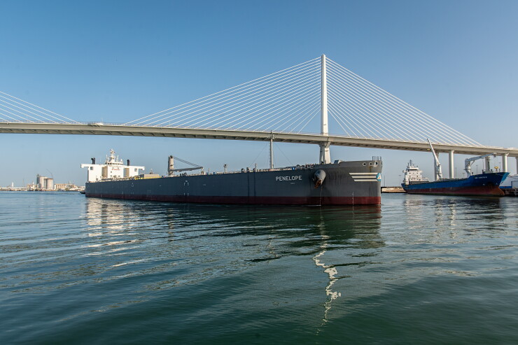 Oil tanker sails under large bridge